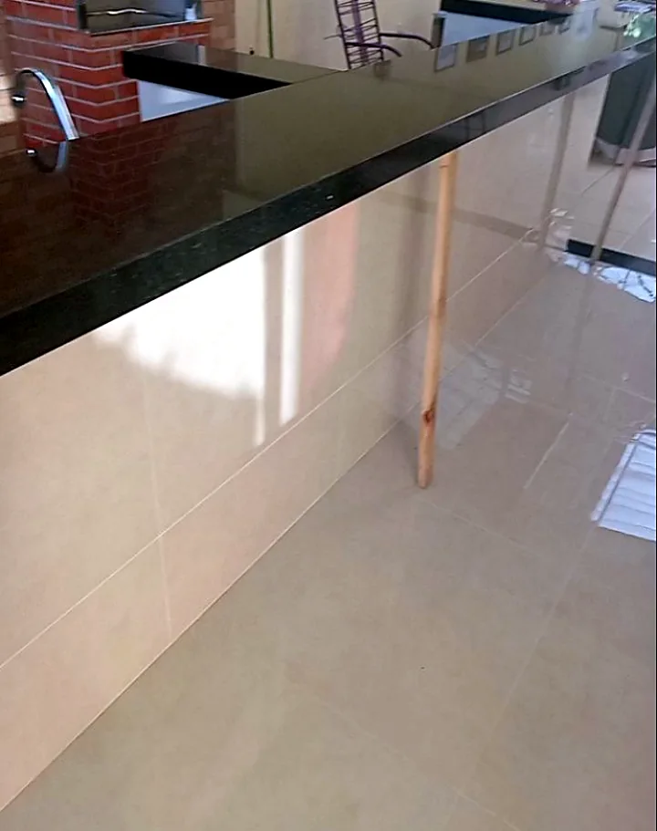 Área gourmet com balcão em granito preto e porcelanato