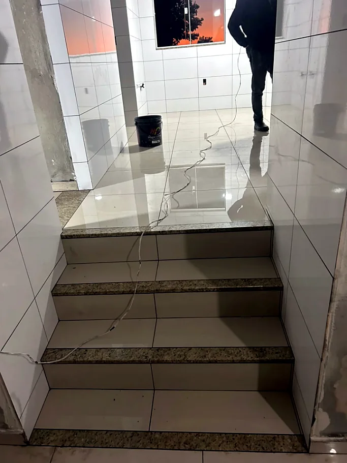 Escada revestida em porcelanato claro com espelhos de granito