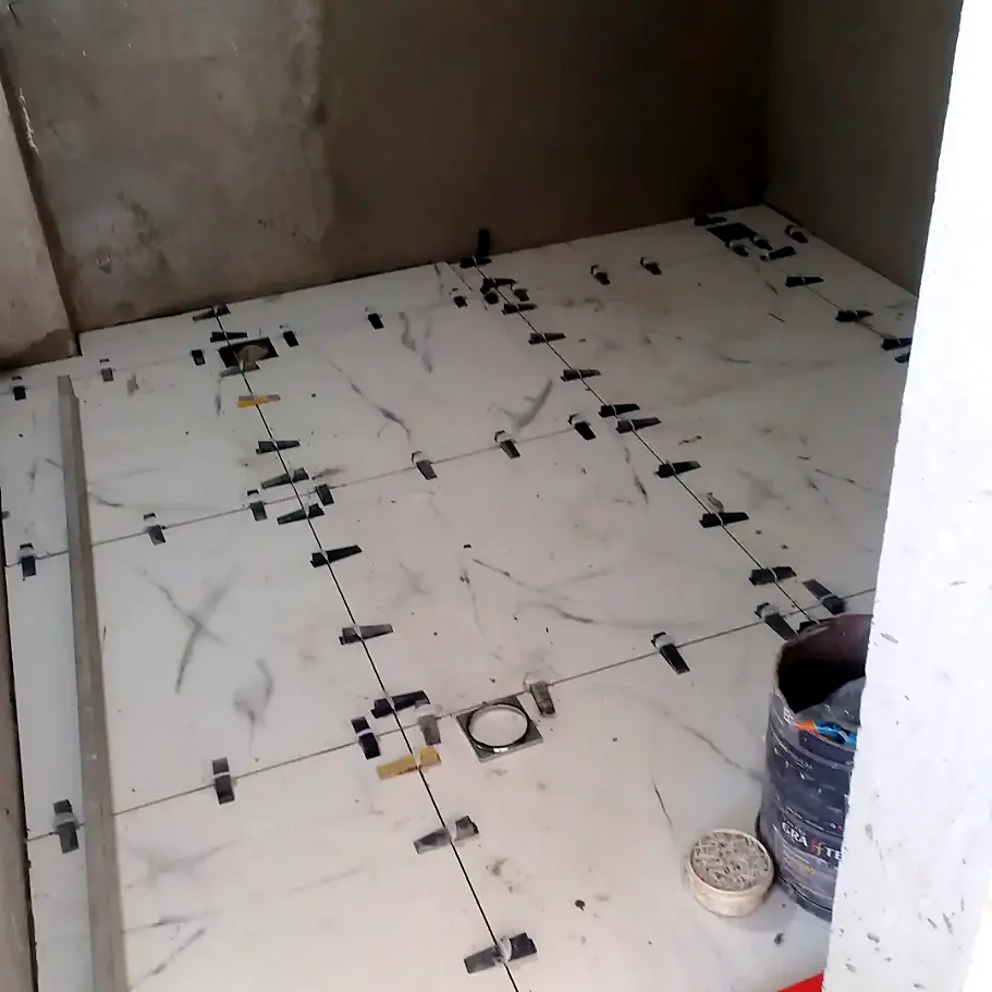Piso de porcelanato sendo assentado com niveladores